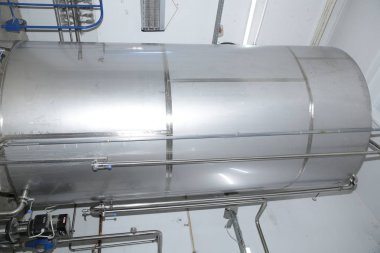 Birbira ve şarap fabrikasında yakın çekim parlak tanklar veya variller. Sanayi Bira ve şarap yapımı. Şaraphane ve bira için ekipman