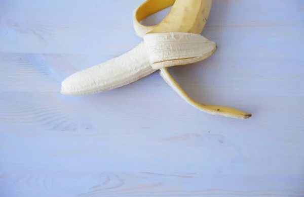 yummy ripe open banana isolated on a blue wooden background. Healthy food. With copy space for text or image.