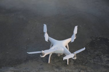 Beyaz insansız hava aracı, beton arka plan da quadrcopter. Metin için kopyalama alanı ile. Hava fotoğrafçılığı ve video çekimi için ekipman. Yeni teknolojiler ve yenilikler kavramı.