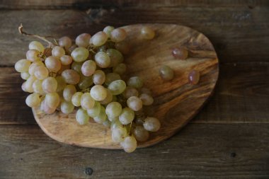 Yakın plan organik sulu üzümler ahşap bir sade masa üzerinde metin için fotokopi alanı var. Düz yatıyordu. Üst görünüm.