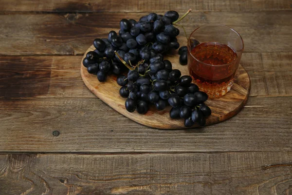 Bicchiere Brandy Vino Grappolo Succoso Uva Nera Tavolo Rustico Legno — Foto Stock