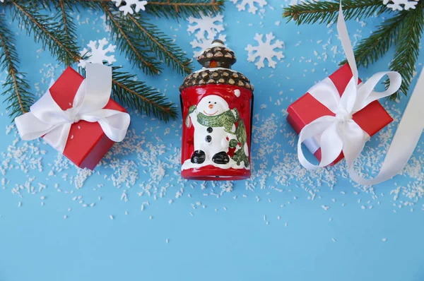 クリスマスツリーの枝と白いリボン 雪だるま そりと雪の結晶と赤のギフトボックスとクリスマスブルーの背景 平置きだ最上階だ背景 パターン はがき テキストのコピースペース — ストック写真