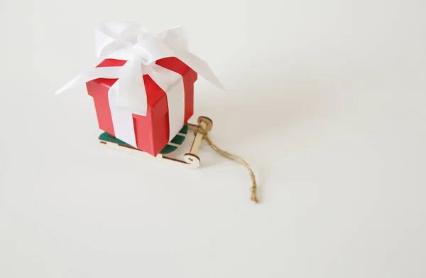 Rote Geschenkschachtel Mit Weißem Band Und Schleife Auf Einem Schlitten — Stockfoto