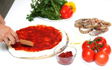 Şef beyaz masada deniz mahsullü pizza ve malzemeler hazırlıyor. Deniz ürünleriyle pizza yapma süreci. Ulusal mutfak kavramı.