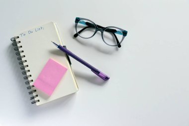 Yapılacaklar listesi yazıt ile not etmek, arka plan beyaz kalem ve gözlük