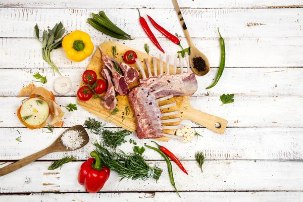 Kuzu pirzola malzemeler Beyaz ahşap zemin üzerinde pişirme ile sunulan