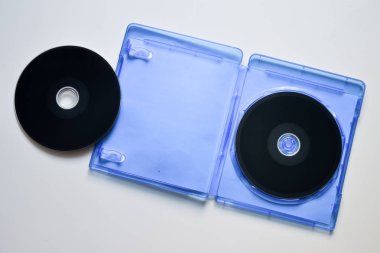 Beyaz zemin üzerine mavi kutu içinde Blu-ray diskler. Üstten görünüm