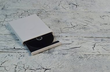 Harici Cd/Dvd/Blu-Ray Disk ile açılan tepsi ve gri Blu-ışın (Bd) disk üzerinde beyaz ahşap arka plan (sol açılı görünüş)