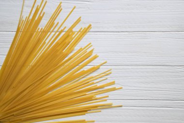 Spagetti Beyaz ahşap zemin üzerinde. Üstten görünüm