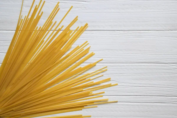 Spagetti Beyaz ahşap zemin üzerinde. Üstten görünüm