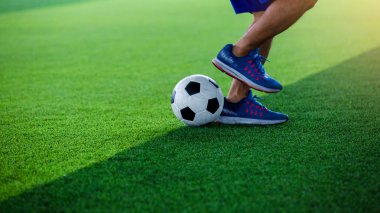 Futbol oyuncu atlama ve stomp yakalamak eğitim ve denetim futbol.