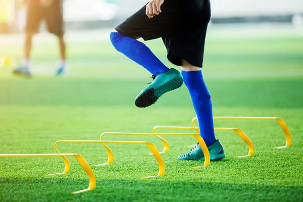 少年足球运动员慢跑和跳跃在标记和黄色障碍之间 足球训练 — 图库照片