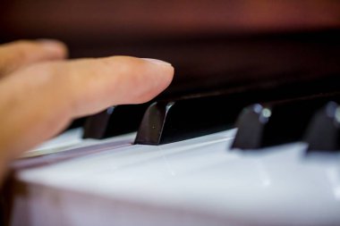 Piyano çalan bir müzik sanatçının parmak Close-up. Yan görünüm araç müzik alet. Piyano klavye arka plan ile seçici odak yakın çekim. Klasik müzik ile siyah beyaz anahtar.