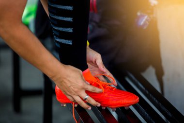Futbol oyuncular stand ve daha önce eğitim futbol spor ayakkabı bağcığı bağlama.