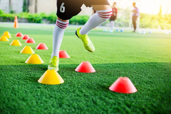 Çocuk futbol oyuncu hareketli hız testi ve Jogging ve futbol eğitim için işaretleyici arasında atlama.