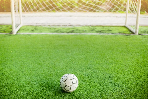 Football on artificial turf and in front of goal. It is for green background and the concept of situation