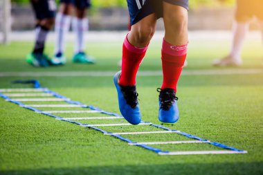 Futbolcu koşu ve futbol eğitim için işaretleyici arasında atlamak. Merdiven matkaplar futbol futbol takımı için egzersizler. Genç oyuncu egzersizleri merdiven matkaplar Doğum.