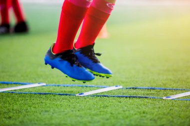 Futbolcu koşu ve futbol eğitim için işaretleyici arasında atlamak. Merdiven matkaplar futbol futbol takımı için egzersizler. Genç oyuncu egzersizleri merdiven matkaplar Doğum.