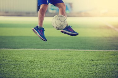 Futbolcu atlayabilir ve topu hedefe suni çim üzerinde ateş. Futbol oyuncusu eğitim veya futbol maçı.