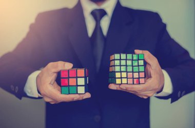 Bangkok, Tayland - 9 Ekim 2018: Rubik küpü - beyin eğitim kavramı ve sorun çözme iş tutan işadamı.