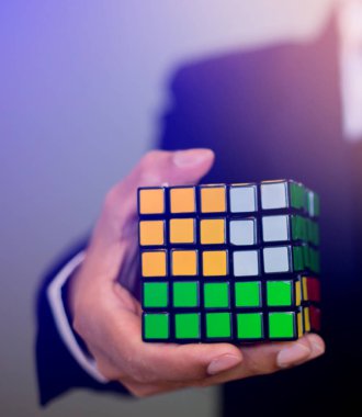 Bangkok, Tayland - 9 Ekim 2018: Rubik küpü - beyin eğitim kavramı ve sorun çözme iş tutan işadamı.