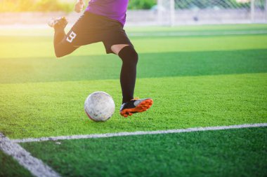 Çocuk Asya futbol oyuncusu touchlines hedefe suni çim üzerinde topu ateş.
