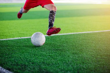 Çocuk Asya futbol oyuncusu touchlines hedefe suni çim üzerinde topu ateş.