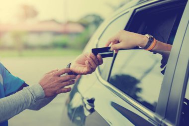 Kadın için seçici odak için yakıt benzin istasyonunda personel kredi kartıyla ödeme.