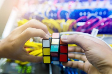 Bangkok, Tayland - 31 Ekim 2018: Rubik küpü - teknik ve çözme sorun ve beyin eğitimi kavramı ile bilgisayar ağ bulanık arka plan iş tutan bilgisayar teknisyen.