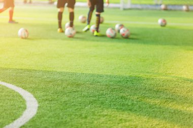 Güneş ışığı ve bulanık futbol oyuncular arka plan ile yeşil suni çim. Futbol Eğitim Akademisi. Yeşil arka plan ve durum kavramı içindir.