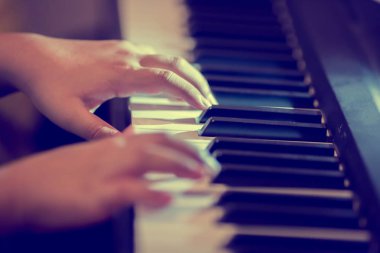 Seçici odak çocuk parmak ve aydınlatma ile piyano piyano anahtar. Konser ya da müzik öğrenme için müzik aleti vardır.