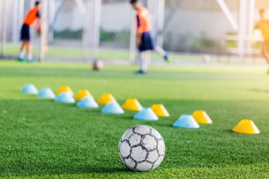Futbol ile bulanık yeşil yapay çim makinesi koniler ve futbol oyuncular eğitim vardır. Futbol Akademisi.