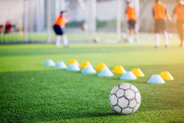 Futbol ile bulanık yeşil yapay çim makinesi koniler ve futbol oyuncular eğitim vardır. Futbol Akademisi.