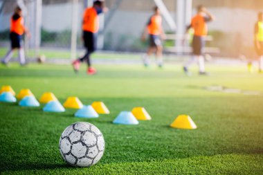 Futbol ile bulanık yeşil yapay çim makinesi koniler ve futbol oyuncular eğitim vardır. Futbol Akademisi.