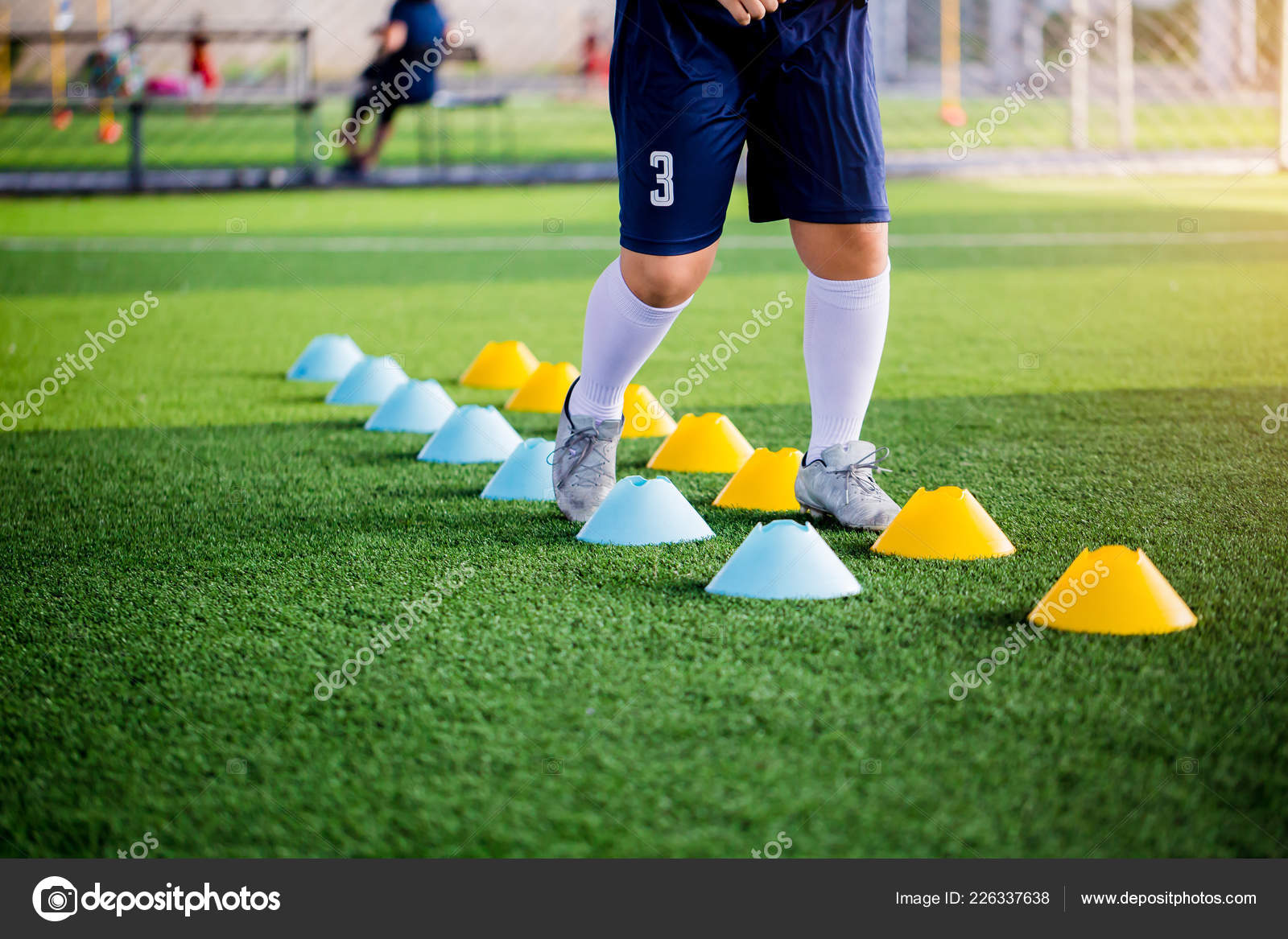 Football Player Jogging and Jump between Cone Markers on Green a