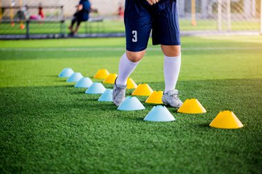 Genç çocuk futbol oyuncuları koşu ve merdiven matkaplar futbol eğitim için arasında atlamak. Merdiven egzersizleri futbol ya da futbol takımı için girer. Çocuk futbol oyuncu egzersizleri merdiven matkaplar Doğum.