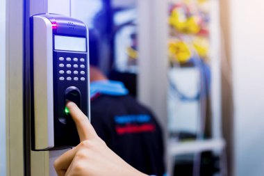 Personel, kontrol odasının ya da veri merkezinin kapısına ulaşmak için parmak taramasıyla elektronik kontrol makinesine basıyor. Veri güvenliği veya veri erişim denetimi kavramı.