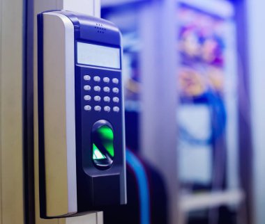 Personel, kontrol odasının ya da veri merkezinin kapısına ulaşmak için parmak taramasıyla elektronik kontrol makinesine basıyor. Veri güvenliği veya veri erişim denetimi kavramı.