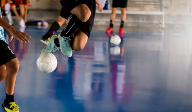 Futsal Oyuncu tuzak ile atlama ve kontrol topu hedefe ateş etmek için. Topu tekmeleme tarafından birbirlerinizle futbolcular. Kapalı futbol spor salonu. Futsal futbolcu, top, futsal kat.