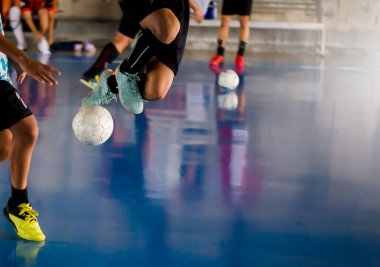 Futsal Oyuncu tuzak ile atlama ve kontrol topu hedefe ateş etmek için. Topu tekmeleme tarafından birbirlerinizle futbolcular. Kapalı futbol spor salonu. Futsal futbolcu, top, futsal kat.