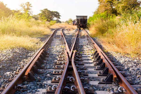 Railroad switch with train in the morning sun. The conception of