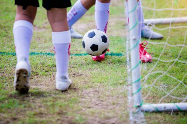 Çocuk futbol oyuncuları tuzak ve kontrol topu gol önünde çekim için. Çocuk futbolcular topu tekmeleme tarafından kavga.