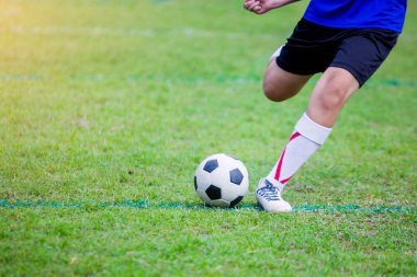 Çocuk futbol oyuncu hız çalıştırmak hedefe yeşil çimenlerin üzerinde topa vurmaya. Futbol oyuncu eğitim veya futbol maç.