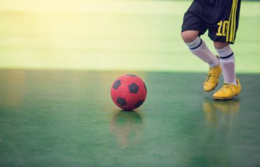 Çocuk futsal oyuncu tuzak ve kontrol topu hedefe ateş etmek için. Topu tekmeleme tarafından birbirlerinizle futbolcular. Kapalı futbol spor salonu. Futsal futbolcu, top