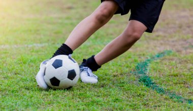 Çocuk futbol oyuncu hız çalıştırmak hedefe yeşil çimenlerin üzerinde topa vurmaya. Futbol oyuncu eğitim veya futbol maç.