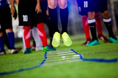 Genç çocuk futbol oyuncuları koşu ve merdiven matkaplar futbol eğitim için arasında atlamak. Merdiven egzersizleri futbol ya da futbol takımı için girer. Çocuk futbol oyuncu egzersizleri merdiven matkaplar Doğum.