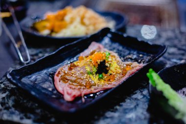 Seçici focust set balık roe ve Tobiko ile Wagyu beef Suşi Japon restoranında siyah plaka üzerinde ızgara. Japon yemekleri, Wagyu dana eti, balık karaca