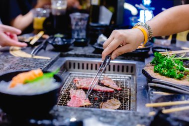 Seçici odak kadının el Japon ızgara restoranında wagyu beef ızgara. Restoranda ızgara soba.