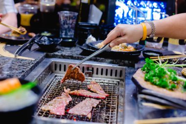Seçici odak kadının el Japon ızgara restoranında wagyu beef ızgara. Restoranda ızgara soba.