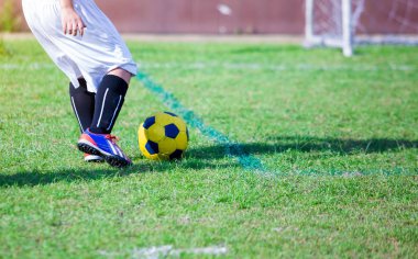 Çocuk futbol oyuncu hız çalıştırmak hedefe yeşil çimenlerin üzerinde topa vurmaya. Futbol oyuncu eğitim veya futbol maç.